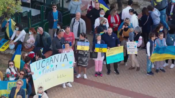 FARO-PORTUGAL - 27. Februar 2022: Antikriegsprotest oder Kundgebung gegen die Invasion der Ukraine. Demonstranten mit Pappbannern und -tafeln, Fahnen. Kein Krieg. — Stockvideo