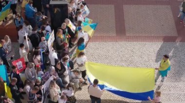 FARO-PORTUGAL - 27 Şubat 2022 Ukrayna 'nın işgaline karşı savaş karşıtı protestolar veya mitingler. Karton pankartlı, pankartlı, bayraklı göstericiler. SAVAŞ yok.