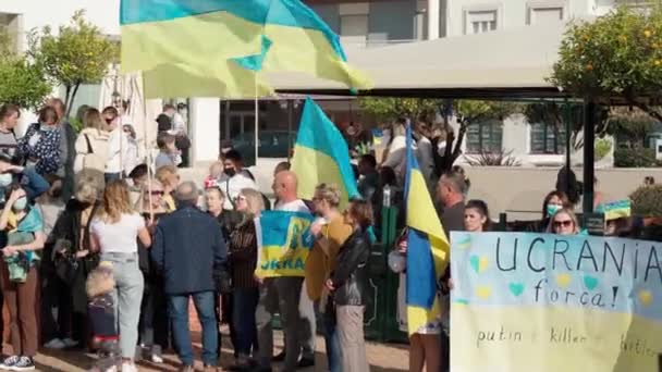 FARO-PORTUGAL - 27. Februar 2022: Antikriegsprotest oder Kundgebung gegen die Invasion der Ukraine. Demonstranten mit Pappbannern und -tafeln, Fahnen. Kein Krieg. — Stockvideo