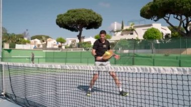 Bir raket yarışmasında bir erkek sporcu raketle topa vuruyor. Yazın kapanış..