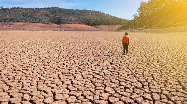 Silhouette d'un homme sur une terre sablonneuse fissurée vide pas fertile lors d'une sécheresse. Le concept de catastrophe écologique sur la planète. Journée ensoleillée — Photo