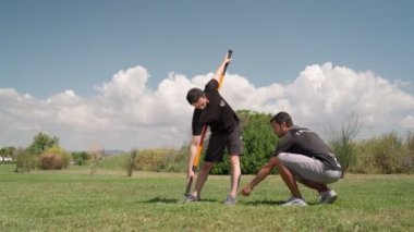 Egzersiz ve rehabilitasyon yapan bir adama yaz aylarında dışardan eşlik eden spor eğitmeni..