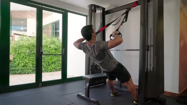 Hispán sportoló gyakorolja fitness övek szíjak, hogy erősítse a hasi hátizmok a tornateremben. — Stock videók