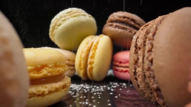 Macaron colorati dolciumi marshmallow su fondo nero riflettente in prospettiva. cosparso di zucchero a velo Extreme macro. — Video Stock