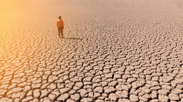 Silhouette d'un homme sur une terre sablonneuse fissurée vide pas fertile lors d'une sécheresse. Le concept de catastrophe écologique sur la planète. Journée ensoleillée — Photo