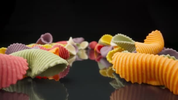 Creatieve veelkleurige pasta farfalle op een zwarte achtergrond in perspectief achtergrond. Het verplaatsen van extreme macro — Stockvideo