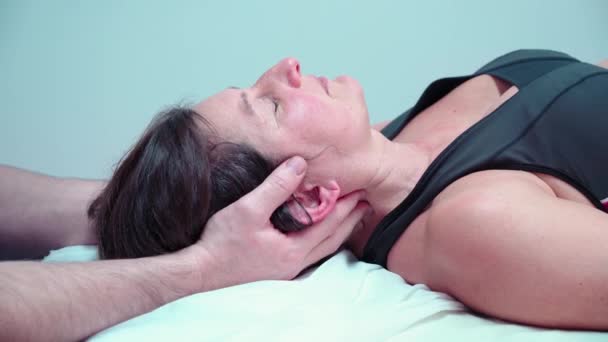 Egy férfi csontkovács osteopath kezeli a női beteg a nyaki fájdalom. A nyaki gerinc fizioterápiája és kezelése. — Stock videók