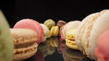 Bakış açısına göre siyah yansıtıcı arka planda renkli badem kurabiyesi şekerlemeleri. Ekstrem kenar makro.