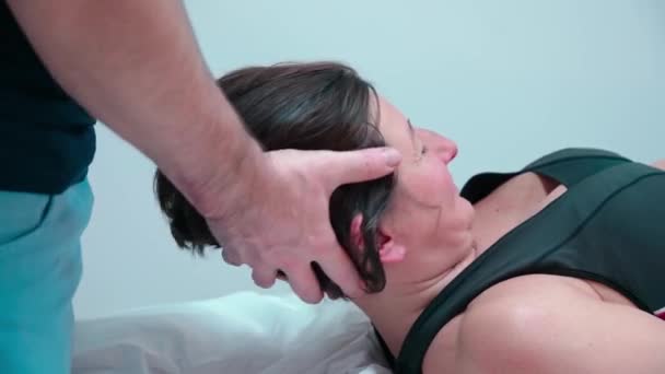 Um quiroprático osteopata do sexo masculino trata uma paciente do sexo feminino para dor no pescoço. Fisioterapia e tratamento da coluna cervical. — Vídeo de Stock