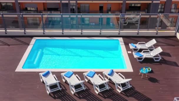 Lyxig pool på taket av huset med solstolar och handdukar för turister att koppla av med klarblått vatten. Infrastrukturens lyxkoncept för framtiden. — Stockvideo