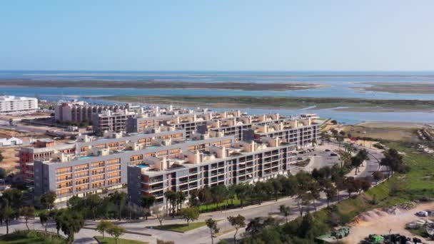 Вид с воздуха на городскую зону португальских домов с современными инфраструктурными бассейнами с видом на море. Португальцы южный город Олхао Риа Формоза — стоковое видео