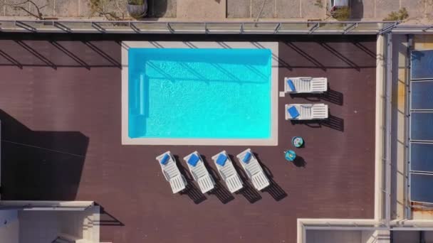 青い水でリラックスする観光客のためのサンラウンジャーとタオル付きの家の屋根の上の高級プール。未来のインフラ贅沢概念. — ストック動画
