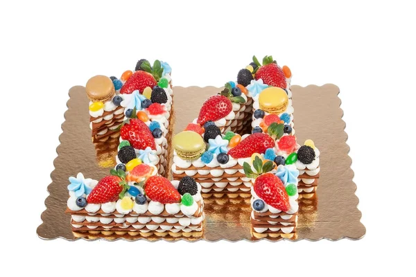 Pastel de cumpleaños creativo hecho de números catorce hechos de frutas y bayas y macarrones sobre un fondo blanco. Primer plano desde arriba. — Foto de Stock