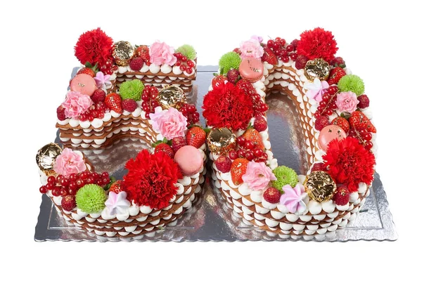 Gâteau original festif en forme de nombres cinquante couverts de bonbons et de fruits avec des fleurs. Sur un fond blanc isolé. — Photo