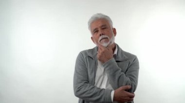 Beyaz bir arka planda stüdyoda depresif bir halde poz veren yaşlı, beyaz bir beyaz adamın portresi. Yaşlanma eğilimi kavramı.