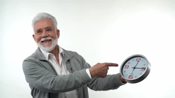 一个年长的高加索式时尚男人的肖像指向时钟的概念时间就是金钱。在白色背景的工作室里趋势老龄化的概念. — 图库视频影像