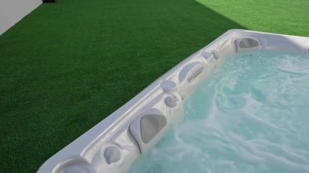 Close-up van het oppervlak van een moderne hot tub voor ontspanningstherapie en revalidatie in een hotel. Bubbels water in een bad onder zuurstofdruk. — Stockvideo