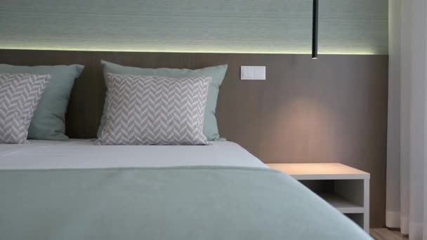베개와 유행하는 장식 이 있는 침실의 현대적 인 침대 방에 클로즈업. 관광객을 위한 호텔. — 비디오