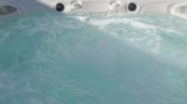Modern bir jakuzinin yüzeyine yakın çekim. Rahatlama terapisi ve bir otelde rehabilitasyon için. Oksijen basıncı altında küvette su kabarcıkları.