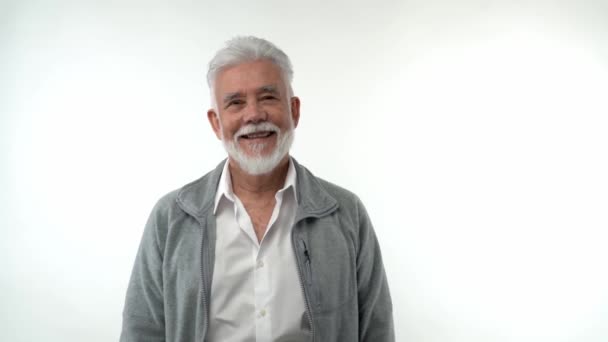 Ein bärtiger älterer Rentner zeigt positive, lächelnde Emotionen auf weißem Hintergrund. — Stockvideo