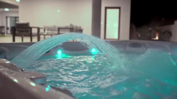 Detailní záběr moderní vířivky pro relaxační terapii a rehabilitaci v hotelu. Proud vody ve vaně padá. Večer na ulici s osvětlením — Stock video