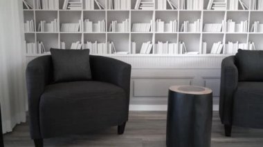 Döşeme sandalyeleri ve kütük şeklinde masası olan modern mobilyalar. Arka planda kitaplarla dolu rafların bir düzeni var. Yüksek kalite 4k görüntü