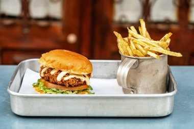 Etli mayonezli klasik hamburger ve tepside alüminyum bardakta kızarmış patates. Yakın plan. Yüksek kalite fotoğraf