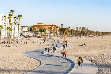 Santa Monica, Kaliforniya, ABD - Şubat 2022: İnsanlar gün batımında yürüyor ve bisiklete biniyor