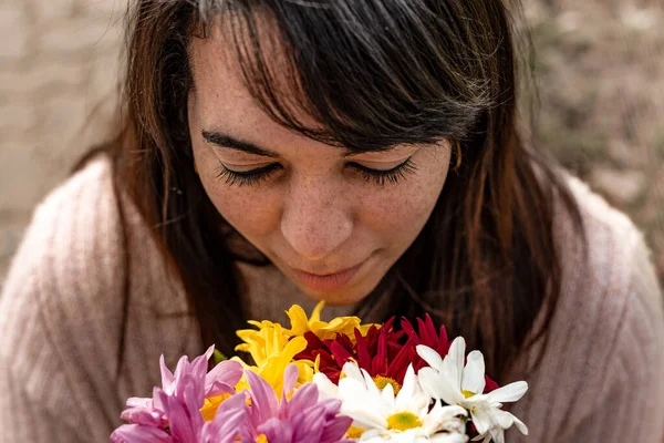 Elinde papatya buketi kokan genç bir kadının yüksek açılı görüntüsü. Yakın plan..  
