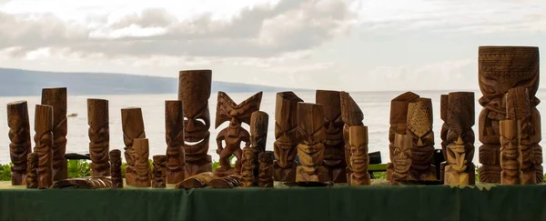 Wooden Tikis on a table near the sea in Kaanapali, Maui