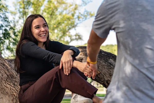 Genç adam, güzel bir kızın elini tutar ve onunla gitmeyi teklif eder. Gülüyor ve mutlu görünüyor.
