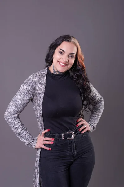 Beautiful woman posing with hands on waist. Studio shot.