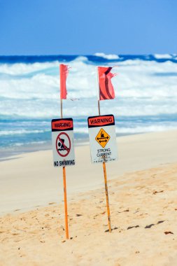 Sahil işaretleri yüzmeyi ve Oahu, Hawaii, ABD 'nin kuzey sahilindeki güçlü akıntılara karşı uyarıyı yasaklıyor.