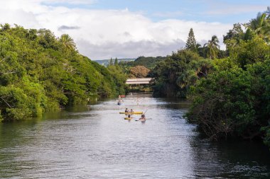 İnsanlar nehirde kano yaparak ayağa kalkıyor.
