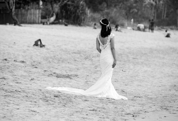 BALI, INDONESIA - FEBRUARY 11, 2017: Rear view black and white of an asian bride on a beach.