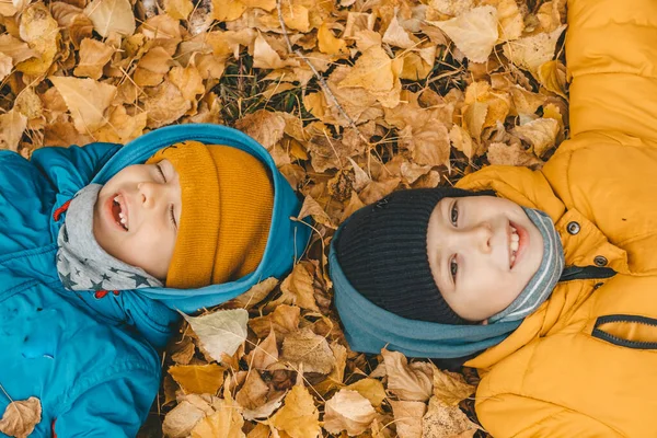 Діти Лежать Жовтому Листі Землі Хлопчики Куртці Розкладають Листя Осінньому — стокове фото