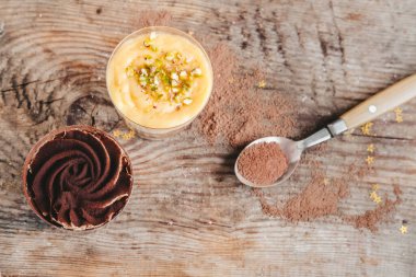 Tahta arka planda bir fincanda çikolatalı turuncu pasta..