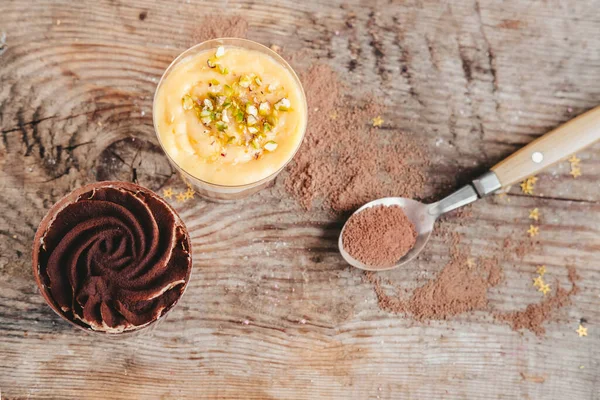 Tahta arka planda bir fincanda çikolatalı turuncu pasta..