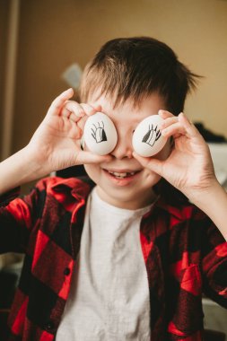 funny picture of a boy with eggs instead of eyes. Eggs with painted eyes. Preparing for Easter. Fun Cooking with the Kids