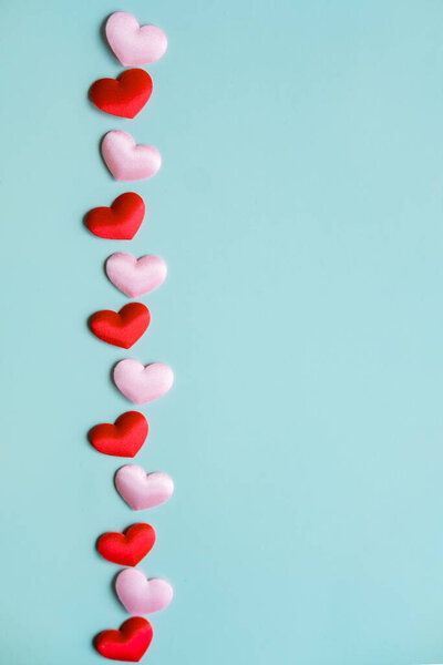 Valentine's Day vertical banner. White and red hearts on pastel blue background, top view, copy space.