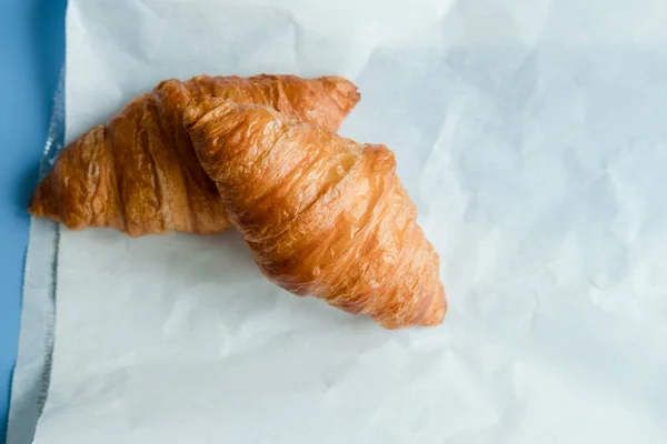 Zwei Croissants Auf Papier Auf Blauem Hintergrund — Stockfoto