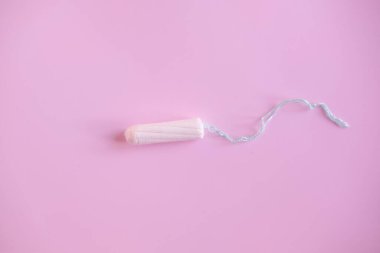 Pembe arka planda kadın tamponu. Kadınlar için hijyenik beyaz tampon.