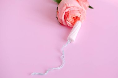 Beyaz tampon ve pembe gül pembe arka planda, kopyalama alanı.