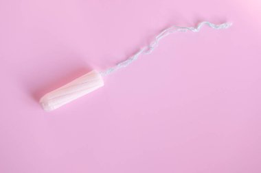 Pembe arka planda kadın tamponu. Kadınlar için hijyenik beyaz tampon.