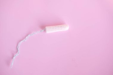 Pembe arka planda kadın tamponu. Kadınlar için hijyenik beyaz tampon.