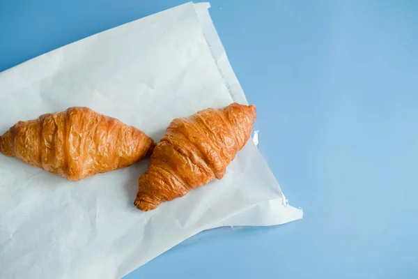 Große Croissants Auf Weißem Papier Auf Blauem Hintergrund Frühstück Morgen — Stockfoto