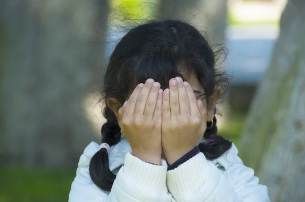 Pequeña niña está jugando a las escondidas —  Fotos de Stock