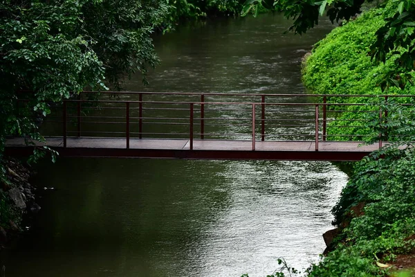 Lonely empty bridge over river with green surrounding