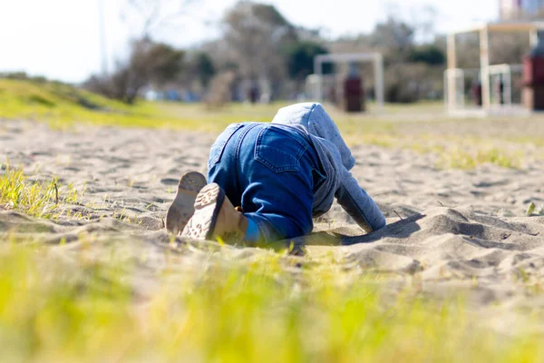 穿着连帽衫和牛仔裤的可爱的男婴在沙滩上散步和玩耍 与幼儿的活动 — 图库照片