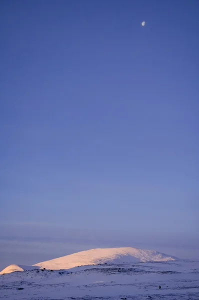 Mond über dem verschneiten Berg — Stockfoto